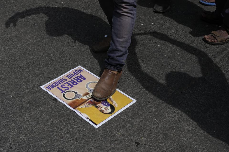 An Indian Muslim stamps on a photo of Nupur Sharma, a spokesperson of governing Hindu nationalist party as they react to the derogatory references to Islam and the Prophet Muhammad made by her during a protest in Mumbai, India, Monday, June 6, 2022. At least five Arab nations have lodged official protests against India, and Pakistan and Afghanistan also reacted strongly Monday to the comments made by two prominent spokespeople from Prime Minister Narendra Modi's Bharatiya Janata Party. (AP Photo/Rafiq Maqbool)