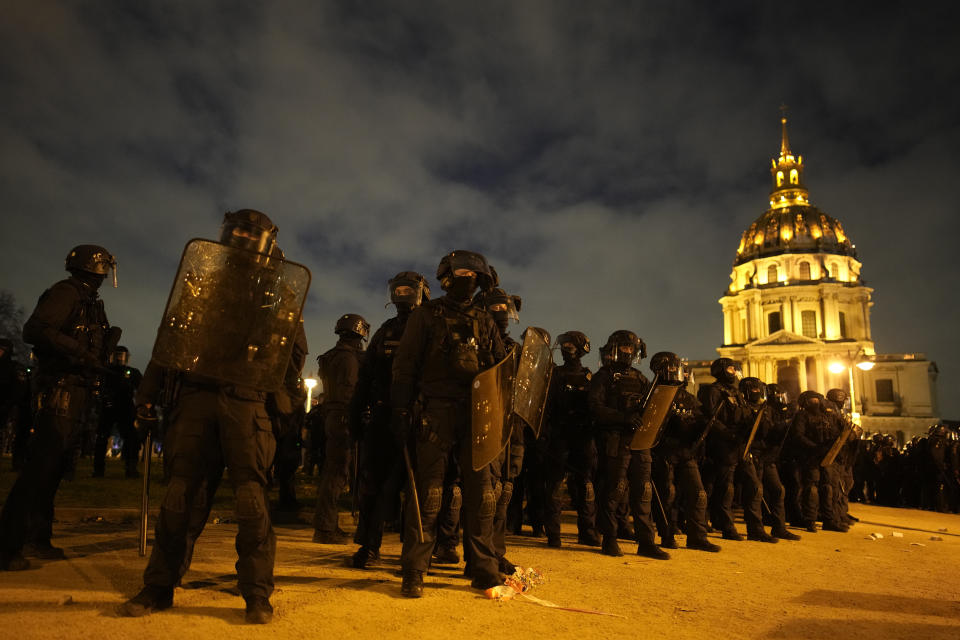 Riot police officers take position near the Invalides monument after a demonstration against plans to push back France's retirement age, Tuesday, Jan. 31, 2023 in Paris. Labor unions aimed to mobilize more than 1 million demonstrators in what one veteran left-wing leader described as a "citizens' insurrection." The nationwide strikes and protests were a crucial test both for President Emmanuel Macron's government and its opponents. (AP Photo/Christophe Ena)