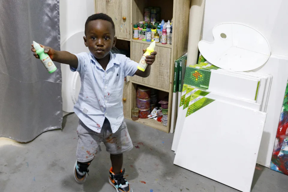 Ace-Liam Nana Sam Ankrah, who will turn two in July, shows off his paint tubes at his mother's art gallery in Accra, Ghana, Monday, May 27, 2024. Ankrah has set the record as the world's youngest male artist. His mother, Chantelle Kukua Eghan, says it all started by accident when her son, who at the time was 6 months old, discovered her paints. (AP Photo/Misper Apawu)