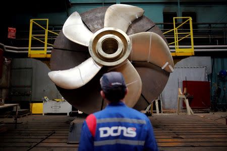 An employee looks at the propeller of a Scorpene submarine at the industrial site of the naval defence company and shipbuilder DCNS in La Montagne near Nantes, France, April 26, 2016. REUTERS/Stephane Mahe/File Photo