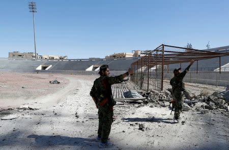 Fighters of Syrian Democratic Forces take a selfie at the stadium after it was retaken from the Islamic State militants, in Raqqa, Syria October 17, 2017. REUTERS/Erik De Castro