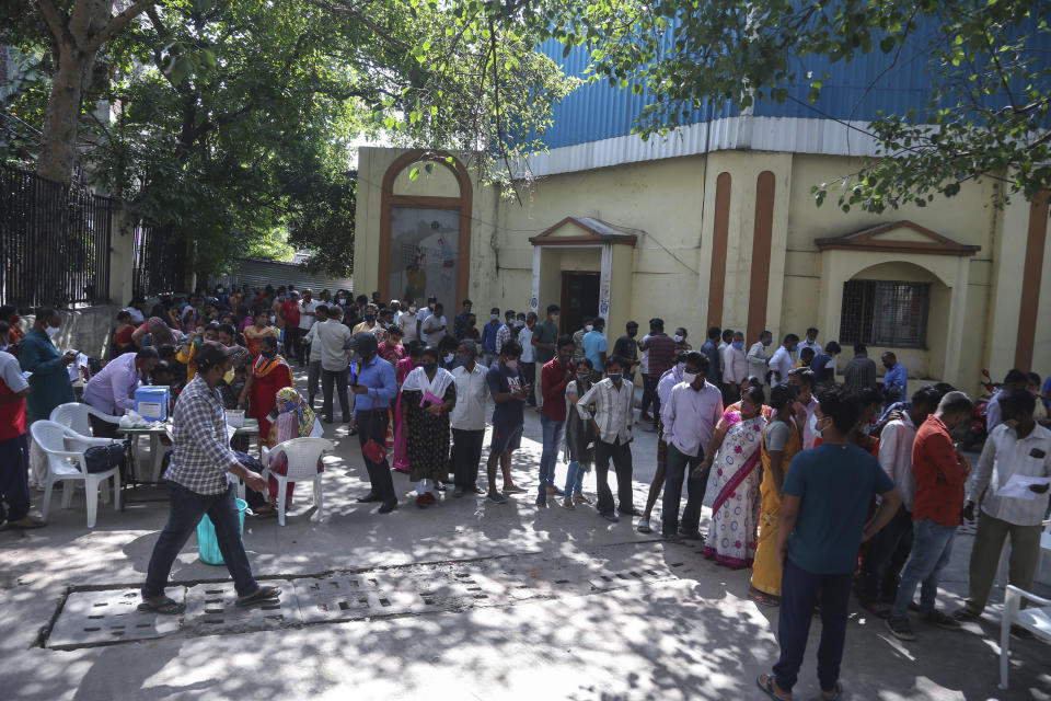 People wait to register their names to get inoculated agains the coronavirus in Hyderabad, India, Thursday, Oct. 21, 2021. India has administered 1 billion doses of COVID-19 vaccine, passing a milestone for the South Asian country where the delta variant fueled its first crushing surge this year. (AP Photo/Mahesh Kumar A.)