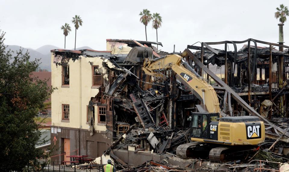 A Caterpillar rips down the charred remains of Bryden Gym at Santa Paula High School on Dec. 2 less than a week after it was destroyed by fire.