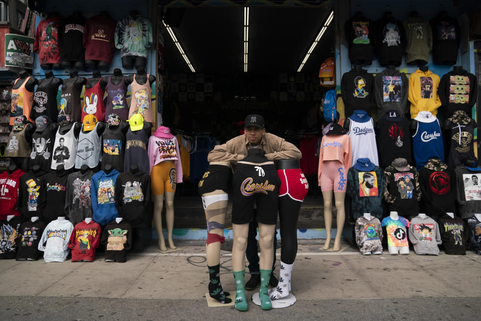 A man leans on a display outside a souvenir shop on the boardwalk in the Venice neighborhood of Los Angeles, Tuesday, June 29, 2021. The proliferation of homeless encampments on Venice Beach has sparked an outcry from residents and created a political spat among Los Angeles leaders. Residents of the gritty bohemian neighborhood that is one of LA's top tourist destinations are frustrated and angry over government inaction that allowed the camps to blossom during the pandemic. (AP Photo/Jae C. Hong)