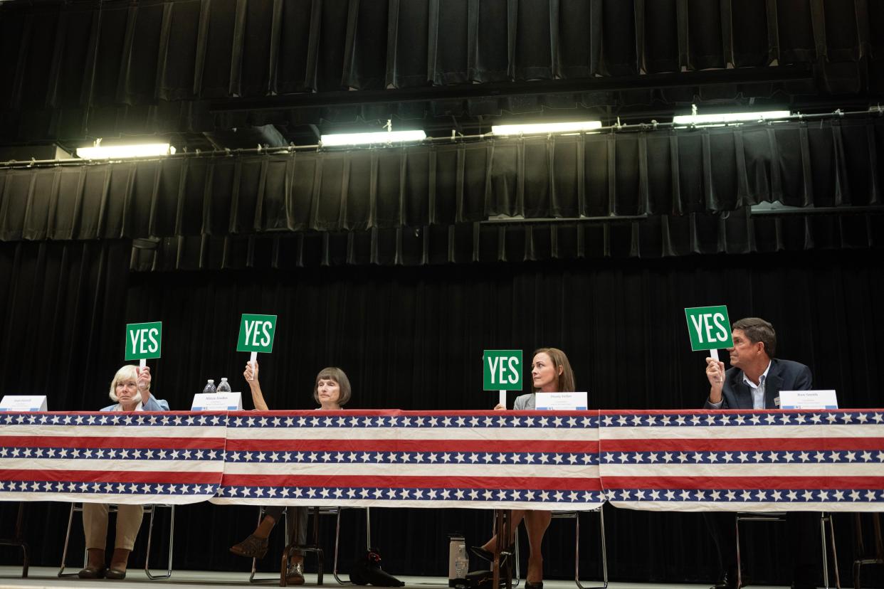Venice City Council Seat 1 candidates Joan Farrell and incumbent Mitzie Fieldler; and Seat 2 candidates Dusty Feller and Ron Smith indicate with paddles that they would prefer that the Venice City Council remain a non-partisan body, in response to a question at a candidate forum hosted by the League of Women Voters of Sarasota County.