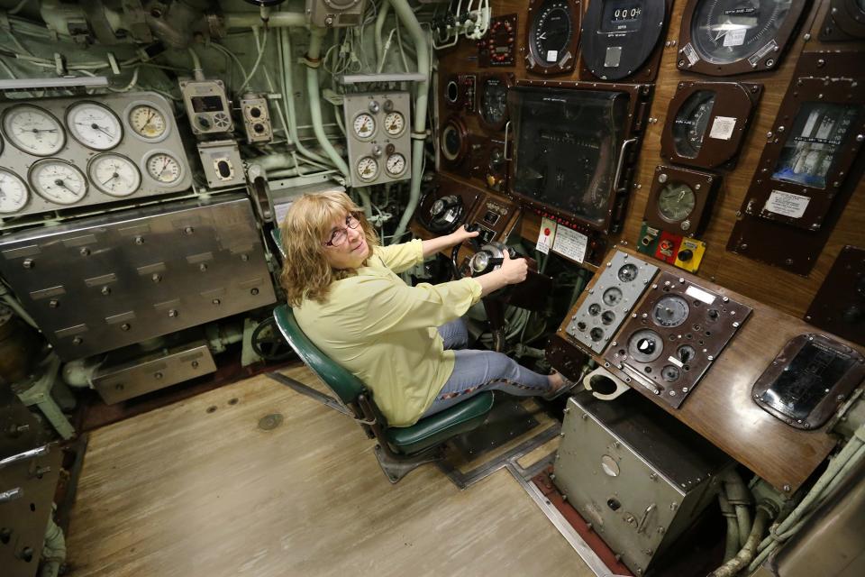 Patricia Violette-Adams, executive director of Albacore Park, takes a seat inside the submarine Monday, May 22, 2023.