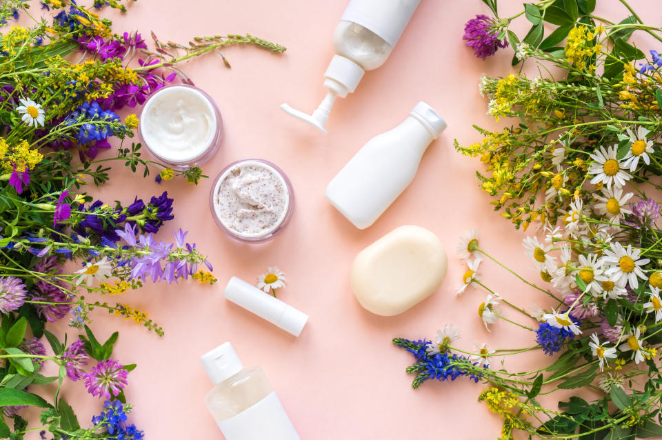 Eco friendly skincare. Natural cosmetics and organic herbs and flowers on pink background, top view, flat lay. Bio research and healthy lifestyle concept.