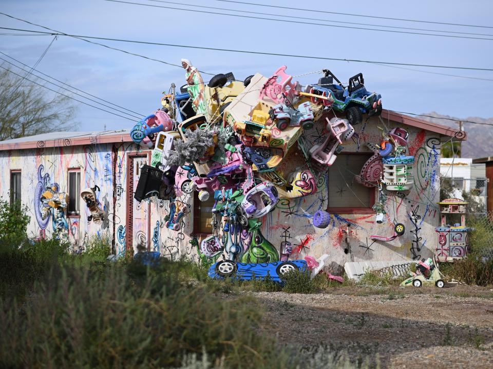 An installation piece by artist Kenny Scharf featuring disused toys and plastic figures embedded on a Bombay Beach abandoned home in 2019.