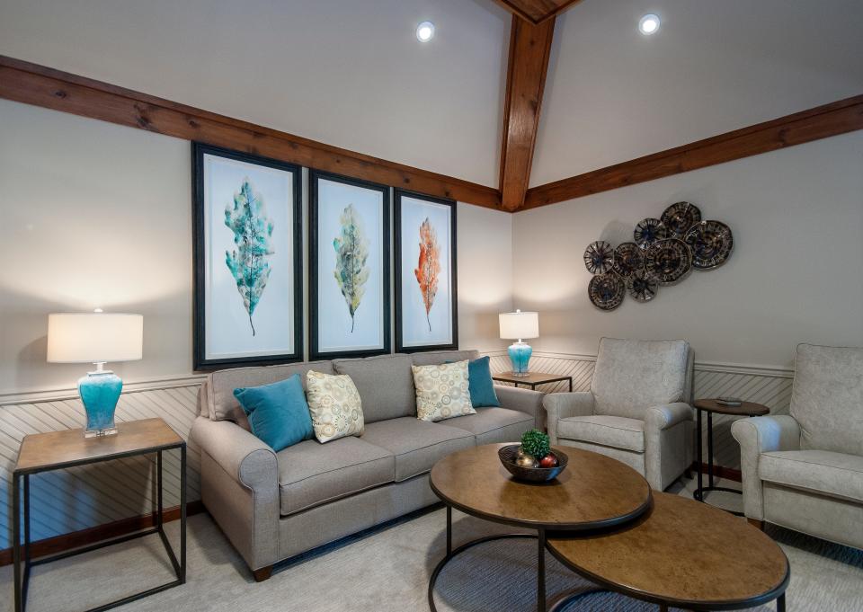 Painting the wainscotting — which used to match the exposed wood beams — dramatically lightened the space in this redesigned living room in Louisville.