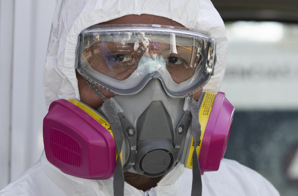 A paramedic wearing hazmat gear prepares to pick up a COVID-18 patient, from the Troya ambulance base in the Iztapalapa district of Mexico City, Tuesday, Feb. 2, 2021. (AP Photo/Marco Ugarte)