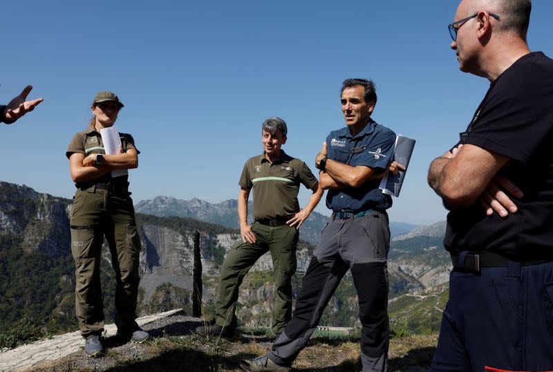 Members of the Brigades for the Investigation for the Prevention of Wildfires talk to rural agents during an investigation near Oviedo