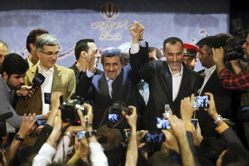 Former Iranian President Mahmoud Ahmadinejad, center, and his close ally Hamid Baghaei join hands after registering their candidacy for the upcoming presidential elections at the Interior Ministry to , in Tehran, Iran, Wednesday, April 12, 2017. Ahmadinejad on Wednesday unexpectedly filed to run in the country's May presidential election, contradicting a recommendation from the supreme leader to stay out of the race. Other close ally of Ahmadinejad, Esfandiar Rahim Mashie accompanies them. (AP Photo/Ebrahim Noroozi)