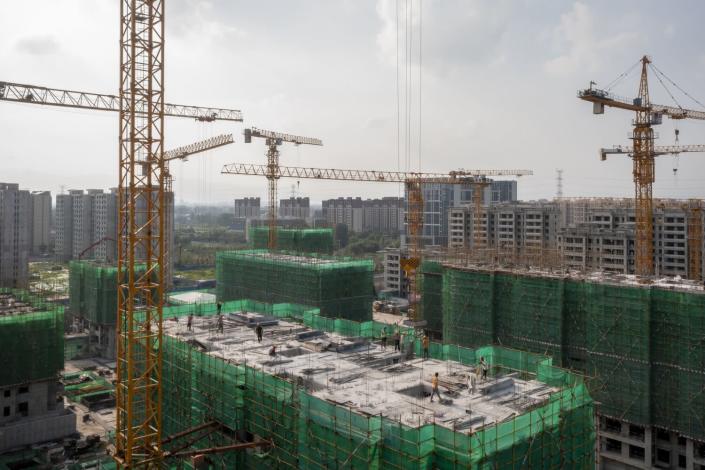 Construction cranes tower over unfinished buildings