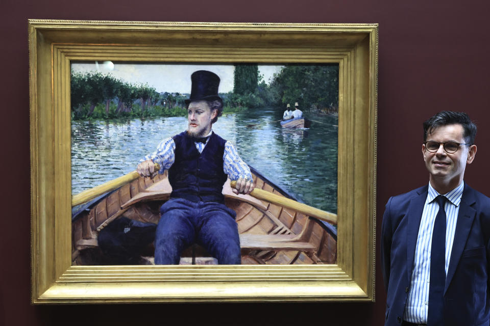 Orsay Museum curator Christophe Leribault, stands beside "A Boating Party" by French painter Gustave Caillebotte at the Orsay Museum, Monday, Jan. 30, 2023 in Paris. France has acquired the stunning impressionist masterpiece for its national collection of art treasures, using a donation from French luxury goods giant LVMH to pay the 43-million euro ($47 million) price tag for Gustave Caillebotte's "A Boating Party." (AP Photo/Aurelien Morissard)