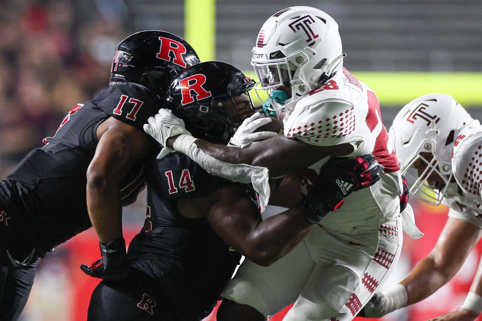 Temple Owls running back Darvon Hubbard (28) is tackled by Rutgers Scarlet Knights defensive lineman Jordan Thompson (14) and linebacker Deion Jennings (17) during the first half at SHI Stadium on Sep 9, 2023, in Piscataway, New Jersey.