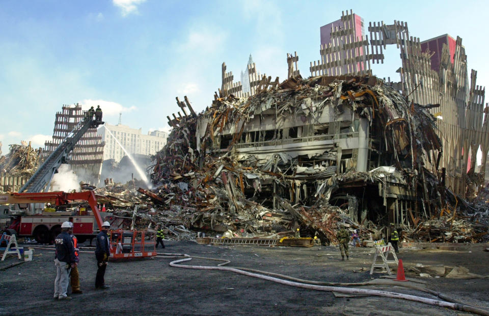 <p>Firefighters pour water on the still-smoldering wreckage at ground zero where the remains of New York’s World Trade Center stand, Sept. 27, 2001. (Photo: Kathy Willens/AP) </p>