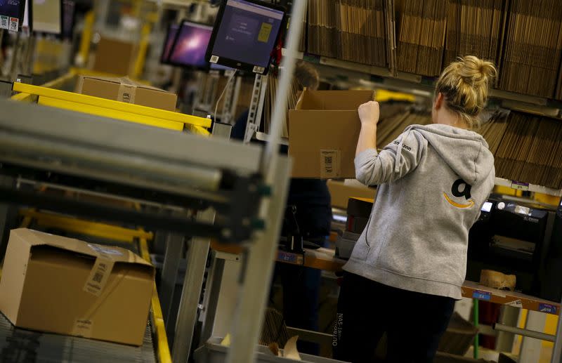 FILE PHOTO: Worker packs products at an Amazon Fulfilment Center in Wroclaw