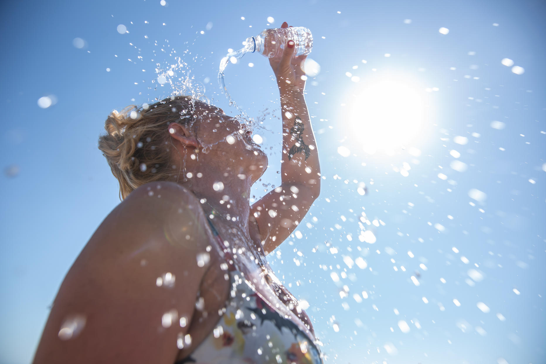 A young woman pours water over herself as a way to stay cool in Singapore's hot weather. 