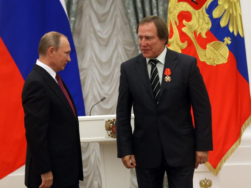 Russian President Vladimir Putin (L) awards businessman and cellist Sergei Roldugin (R) at the Kremlin in 2016.