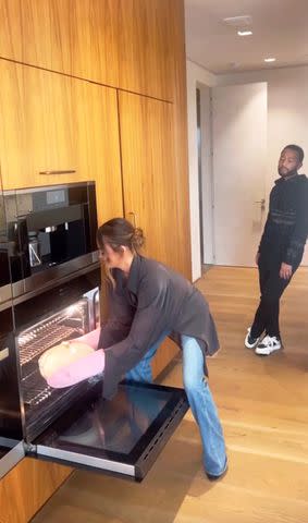 <p>Chrissy Teigen/Instagram</p> Chrissy Teigen (L) and John Legend (R) in their kitchen