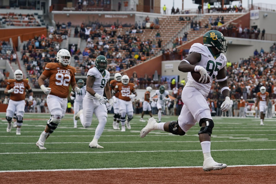 Baylor defensive lineman Gabe Hall (95) returns a fumble for a touchdown against Texas during the second half of an NCAA college football game in Austin, Texas, Friday, Nov. 25, 2022. (AP Photo/Eric Gay)