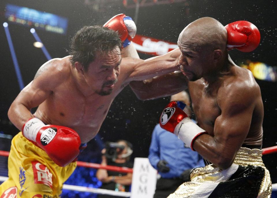 Manny Pacquiao, izquierda, lanza un golpe contra Floyd Mayweather Jr. en su pelea del 2 de mayo de 2015 en Las Vegas. (AP Photo/John Locher, File)