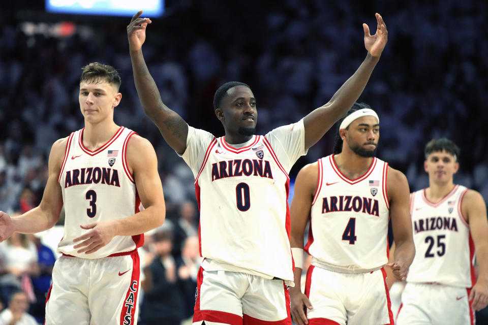 Arizona guards Courtney Ramey (0), Pelle Larsson (3), Kylan Boswell (4), and Kerr Kriisa (25) celebrate with the fans after defeating UCLA 58-52 during an NCAA college basketball game, Saturday, Jan. 21, 2023, in Tucson, Ariz. (AP Photo/Rick Scuteri)