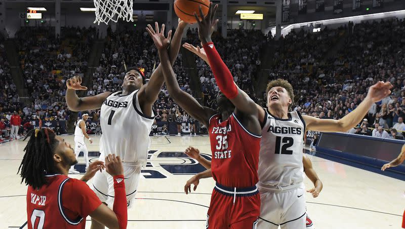 Utah State forward Great Osobor (1) and guard Mason Falslev fight for a rebound during game against Fresno State Saturday, Jan. 20, 2024, in Logan, Utah.