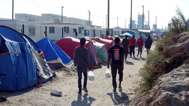 Migrants walk in the northern area of the camp called the