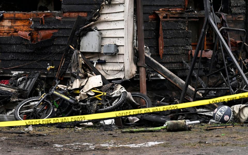 A bicycle and children's toys outside the burned-out home