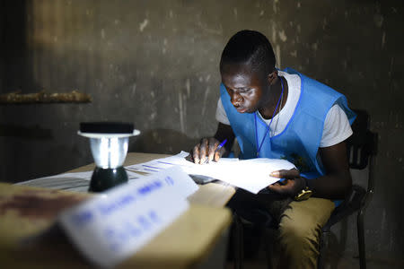 An electoral worker counts the votes during a presidential run-off in Freetown, Sierra Leone March 31, 2018. REUTERS/Olivia Acland