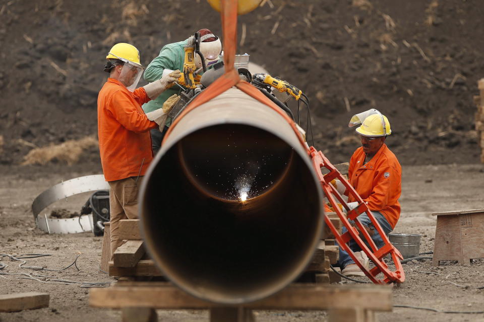 Enbridge workers weld pipe just west of Morden, Man., Thursday, Aug. 16, 2018. Enbridge Inc. says it expects its earnings per share to grow at a compounded annual rate of four to six per cent through 2025.THE CANADIAN PRESS/John Woods