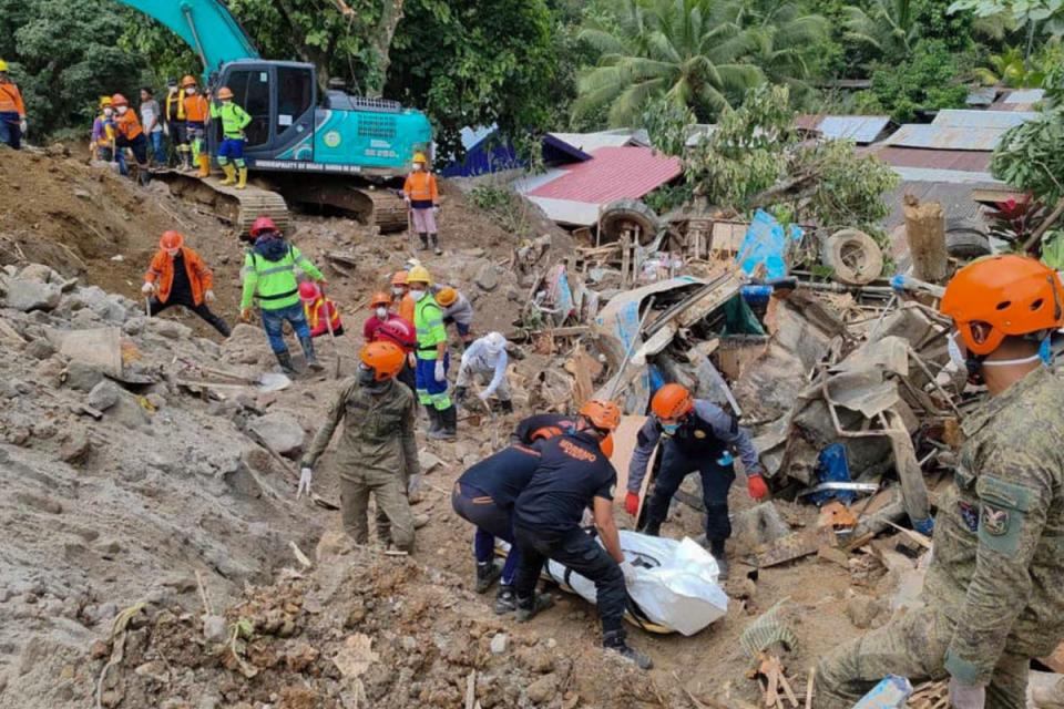 In this 9 Feburary 2024 handout photo from Municipality of Monkayo, rescuers recover bodies at the landslide-hit village of Maco in Davao de Oro province, southern Philippines (AP)