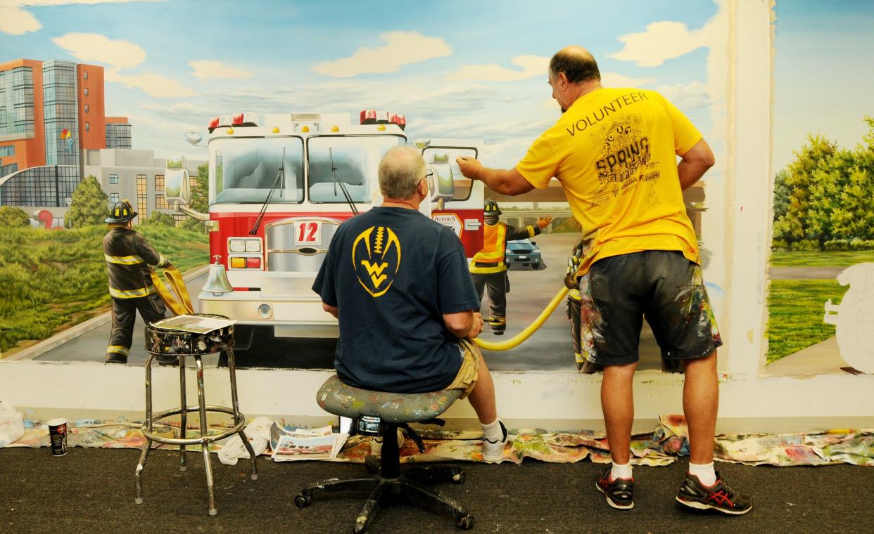 Joe "Artbrush" Puskas and artist Keith Jones paint details on a Firehouse Subs mural that will pay tribute to the local communities where the store will be located in October 2017.