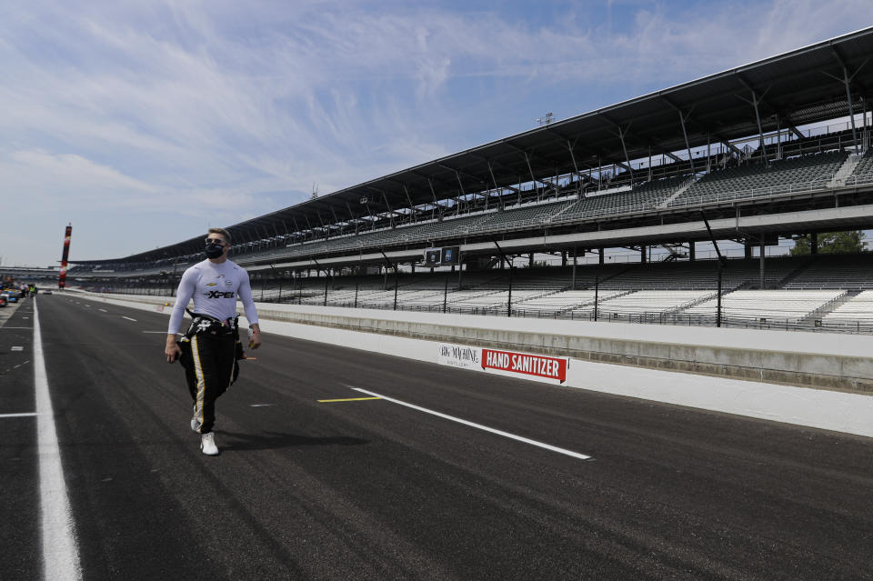 FILE - In this July 30, 2020, file photo, race driver Josef Newgarden walks through the pit area before the start of practice for an IndyCar auto race at Indianapolis Motor Speedway in Indianapolis. There was always going to be an Indianapolis 500 this year, be it with full fans, limited fans or, where Indianapolis Motor Speedway finally landed, with no fans at all. Roger Penske has been determined for this staple of American sporting events to go on and the track will open Wednesday, Aug. 12 for activity. (AP Photo/Darron Cummings)