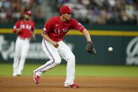 Texas Rangers shortstop Corey Seager reaches out to field a ground out by Washington Nationals' Victor Robles in the fifth inning of a baseball game, Friday, June 24, 2022, in Arlington, Texas. (AP Photo/Tony Gutierrez)