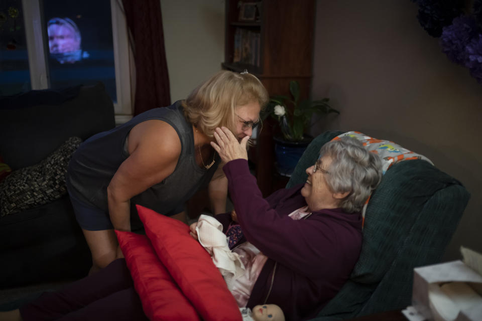 Betty Bednarowski strokes the cheek of her daughter, Susan Ryder, as they return from using the bathroom, Monday, Nov. 29, 2021, in Rotterdam Junction, N.Y. (AP Photo/Wong Maye-E)