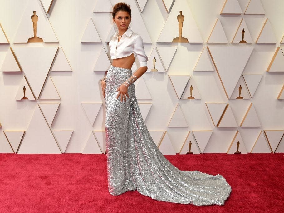 Zendaya at the 2022 Oscars wearing a sparkly silver skirt and cropped white blouse