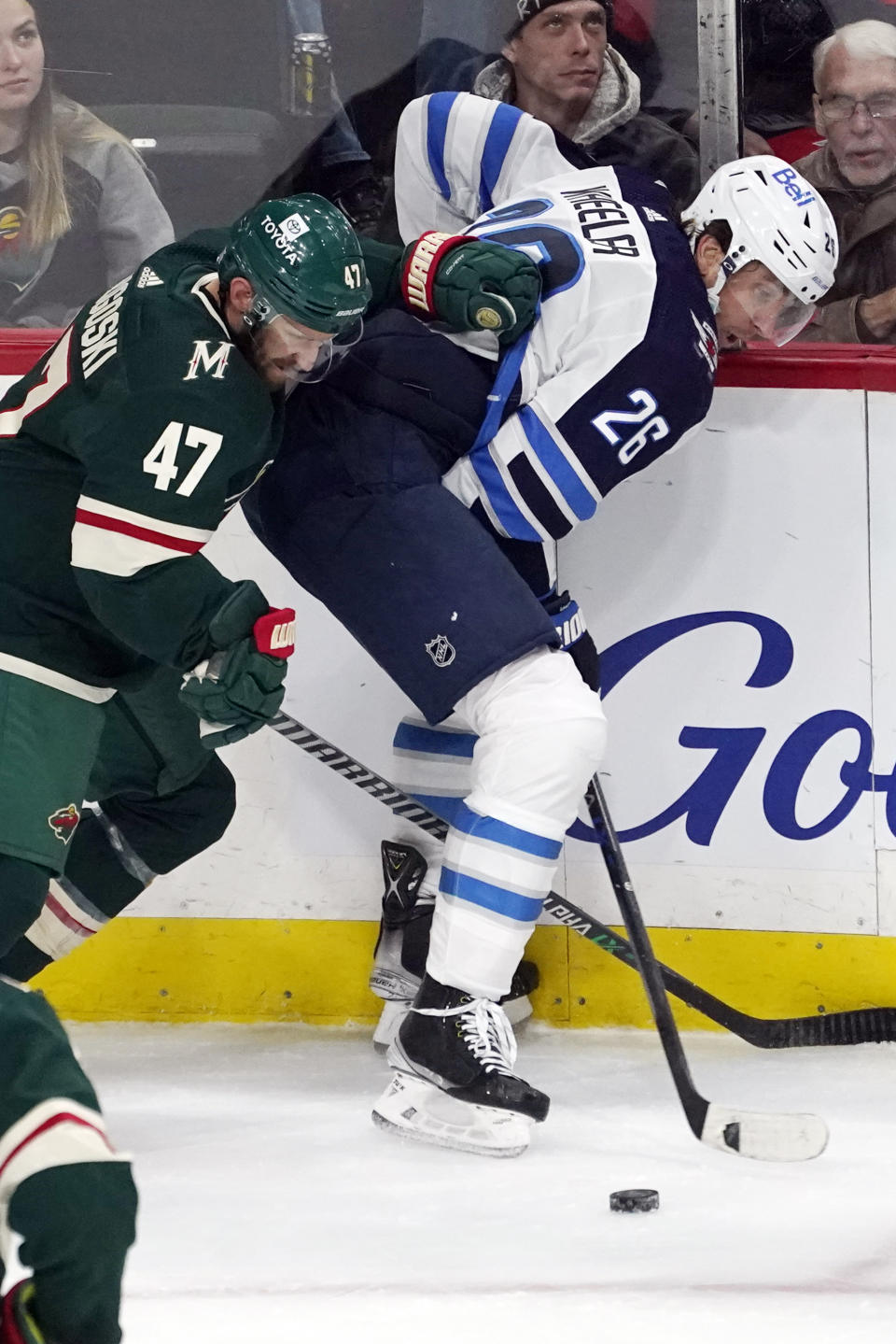 Minnesota Wild's Alex Goligoski (47) and Winnipeg Jets' Blake Wheeler (26) battle for the puck in the first period of an NHL hockey game, Friday, Nov. 26, 2021, in St. Paul, Minn. (AP Photo/Jim Mone)