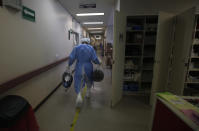 A health worker carries the clothes of COVID-19 patients that have recovered from the disease and are being discharged from the Mexico City Ajusco Medio General Hospital, Wednesday, Dec. 2. 2020. Mexico continues to report an increase in the number of coronavirus cases, with Mexico City continuing to report the biggest portion of the surge. (AP Photo/Marco Ugarte)