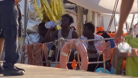 A still image from a video footage shows migrants sitting on board of a migrant rescue boat "Alex", after the vessel docked at the port of Lampedusa in defiance of a ban on entering Italian waters, in Lampedusa