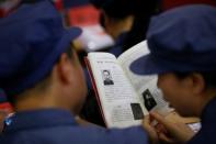 Participants read a textbook during a history lesson at the Red Culture Training Centre during a Communist team-building course extolling the spirit of the Long March in Jinggangshan, Jiangxi province, China, September 14, 2017. REUTERS/Thomas Peter