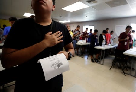 Immigrants say the Pledge of Allegiance in a writing class at the U.S. government’s newest holding center for migrant children in Carrizo Springs