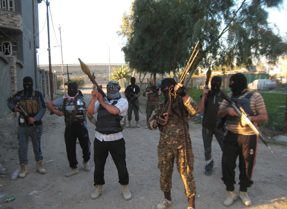 FILE - In this file photo taken on March 15, 2014, masked anti-government gunmen hold their weapons as they patrol in Fallujah, Iraq. Iraqi military officials are warning that efforts to clear militants from Fallujah and parts of nearby Ramadi are proving much more difficult than they anticipated when the jihadists showed up three months ago. That realization, as they acknowledged during a recent tour of special forces operations, casts doubt on Iraq's ability to hold elections in Fallujah next month. (AP Photo, File)