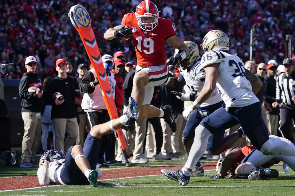 Georgia tight end Brock Bowers (19) tries to get past Charleston Southern defenders Dominic Pagano (32), Anton Williams (31) and Trayson Fowler (36) after a catch in the first half of an NCAA college football game Saturday, Nov. 20, 2021, in Athens, Ga. (AP Photo/John Bazemore)