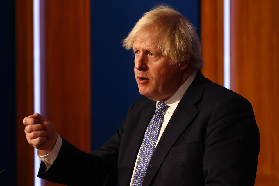 LONDON, ENGLAND - DECEMBER 08: British prime Minister Boris Johnson gestures as he gives a press conference at 10 Downing Street on December 8, 2021 in London, England. During the press conference, the Prime Minister announced that the government will implement its “Plan B” due to the rapid transmission of the Omicron variant. The work from home guidance has been reintroduced, mask wearing at public indoor venues will be enforced and mandatory COVID-19 vaccination passports will be required for entrance into crowded venues such as nightclubs. (Photo by Adrian Dennis-WPA Pool/Getty Images)