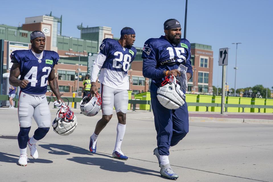 New England Patriots' Ezekiel Elliott along with J.J. Taylor (42) and Ameer Speed (28) walk to practice for NFL football training camp Wednesday, Aug. 16, 2023, in Green Bay, Wis. (AP Photo/Morry Gash)