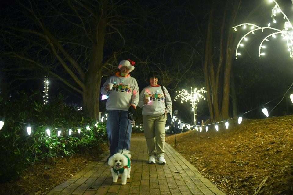 FILE - Richard and Mary Peterson walk with their dog Peebles through Hopelands Gardens in Aiken, S.C., on Monday, Dec. 18, 2023. The Hopelands Concert Series continues to run every Monday.