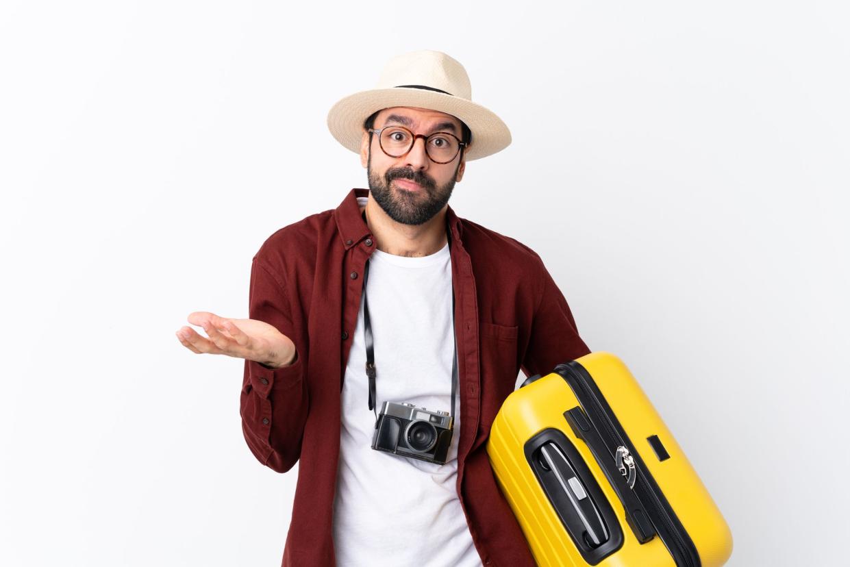 Traveler man man with beard holding a suitcase