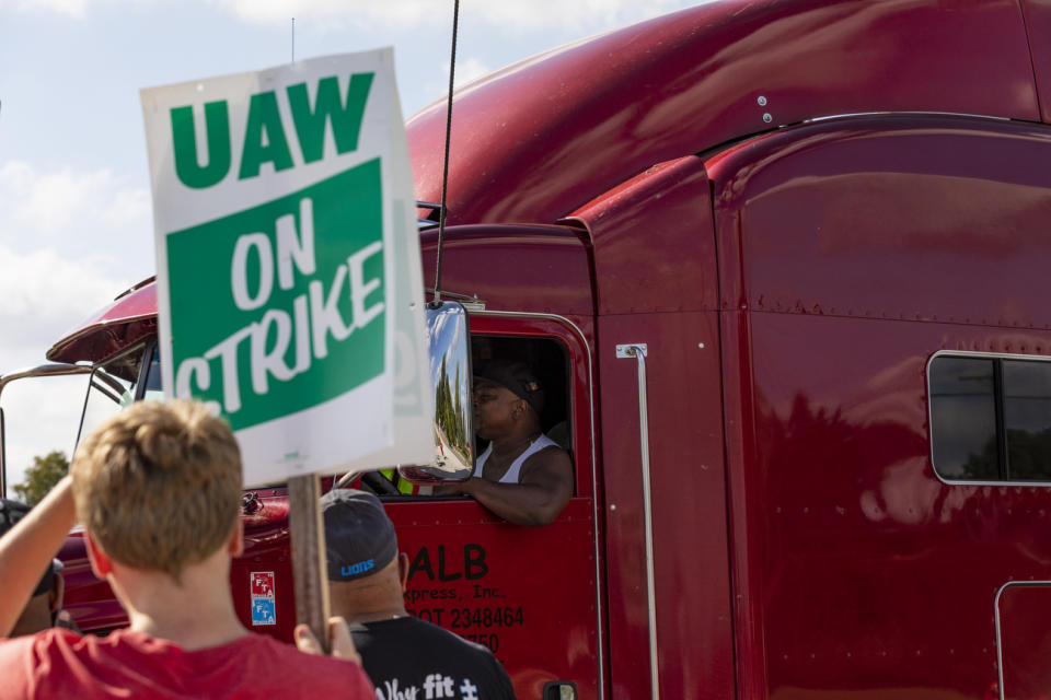 A semi-truck driver entering the GM Davison Road Processing Center in Burton passes union members striking. United Automobile Workers remain on strike against GM on Tuesday, Sept. 17, 2019 in Burton, Mich. (Sara Faraj/The Flint Journal via AP)